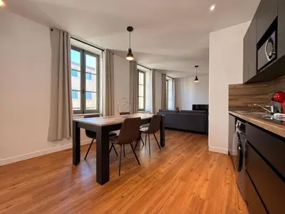a kitchen and dining room with a table and chairs at L'Ébène - Wifi - Proche des Halles et du centre ville in Narbonne