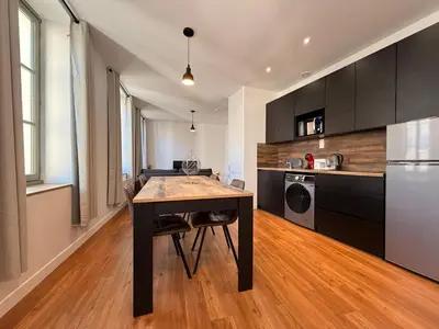 a kitchen with a wooden table and a kitchen with a refrigerator at L'Ébène - Wifi - Proche des Halles et du centre ville in Narbonne