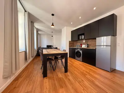 a kitchen with a wooden table and a dining room at L'Ébène - Wifi - Proche des Halles et du centre ville in Narbonne