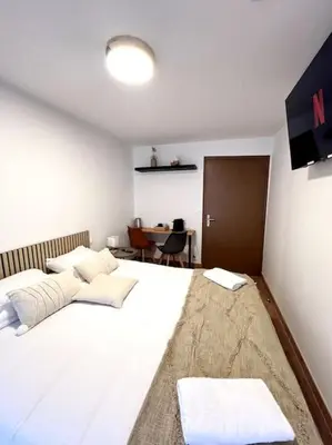 a bedroom with a large white bed with two pillows at Les chambres de la bastide - 303 in Carcassonne