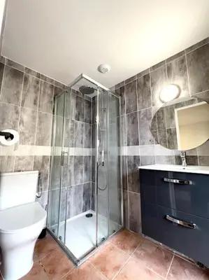 a bathroom with a toilet and a glass shower at Les chambres de la bastide - 303 in Carcassonne