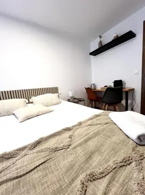 a bedroom with a large white bed and a desk at Les chambres de la bastide - 303 in Carcassonne
