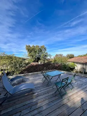 a patio with a table and chairs on a deck at le gîte du Cantou in Lautrec