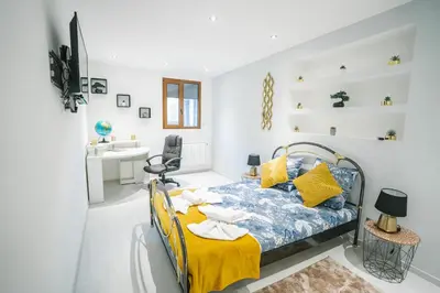 a bedroom with a bed and a desk and a sink at La Pierre Dorée-3 chambre 2 salle de bain-AO in Puicheric