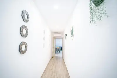 a hallway with white walls and clocks on the wall at La Pierre Dorée-3 chambre 2 salle de bain-AO in Puicheric