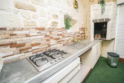a kitchen with a stove and a brick wall at La Pierre Dorée-3 chambre 2 salle de bain-AO in Puicheric