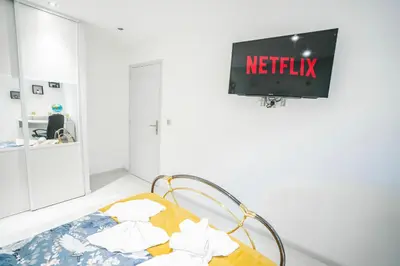 a hospital room with a bed with a netflix sign on the wall at La Pierre Dorée-3 chambre 2 salle de bain-AO in Puicheric