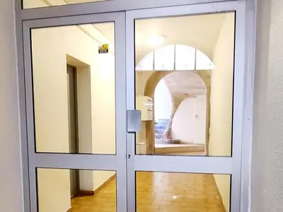 a glass door with a mirror in a hallway at Le Marceau Terrasse Sur Le Toit in Narbonne