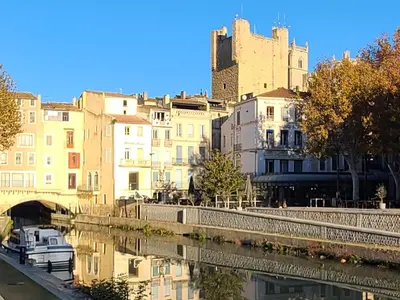 a city with a castle and a river with buildings at Le Marceau Terrasse Sur Le Toit in Narbonne