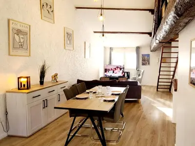 a dining room and living room with a table and chairs at Le Marceau Terrasse Sur Le Toit in Narbonne