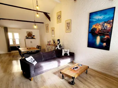 a living room with a couch and a table at Le Marceau Terrasse Sur Le Toit in Narbonne