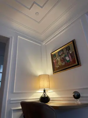 a table with a lamp and a picture on a wall at Apparemment luxueux niché dans les arbres in Narbonne