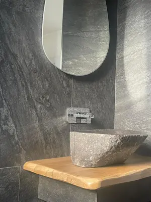 a bathroom with a marble sink and a mirror at Apparemment luxueux niché dans les arbres in Narbonne