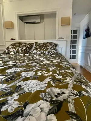 a bed in a bedroom with a blanket on it at Apparemment luxueux niché dans les arbres in Narbonne