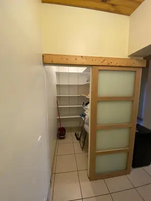 a closet with a glass door in a room at Appartement T2 spacieux in Trévillach