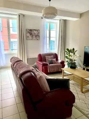 a living room with a couch and a chair at T3 situé près de la Place Carnot in Carcassone