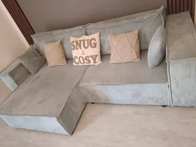 a couch with pillows on it in a living room at Le Cosy Bernard , Parking, Piscine, Netflix in Carcassonne