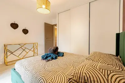 a large bed with a stuffed animal sitting on top of it at Le Cosy Bernard , Parking, Piscine, Netflix in Carcassonne