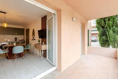 a kitchen and living room with a large sliding glass door at Le Cosy Bernard , Parking, Piscine, Netflix in Carcassonne