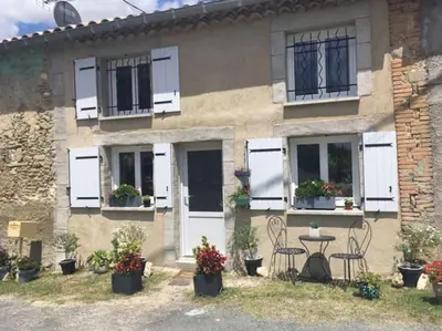 a house with white shutters and a table and chairs at Charmante Maison l Jardin l Clim in Carbes