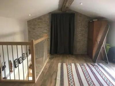 a room with a staircase and a black curtain at Charmante Maison l Jardin l Clim in Carbes