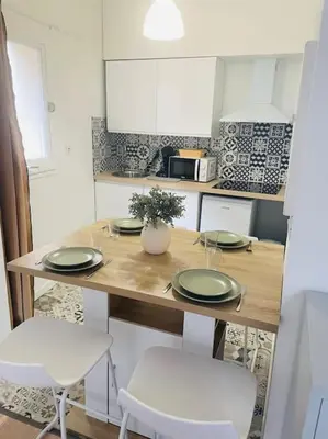a kitchen with a table with plates and chairs at Le Borel I in Castres