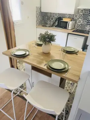 a kitchen with a table with plates and chairs at Le Borel I in Castres