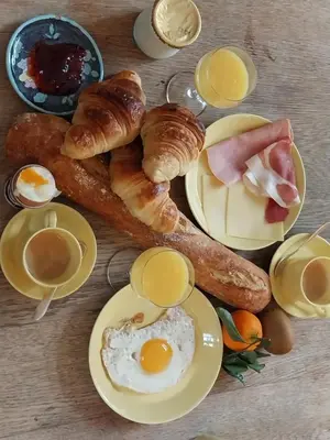 a table with eggs bread and croissants and cups of coffee at B&B Hugo Puisserguier in Puisserguier