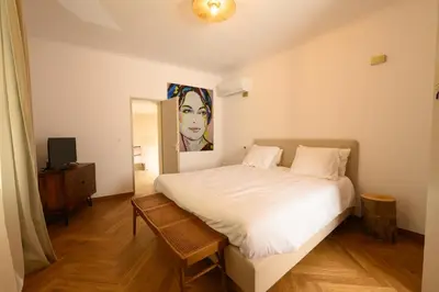 a bedroom with a white bed and a television at B&B Hugo Puisserguier in Puisserguier