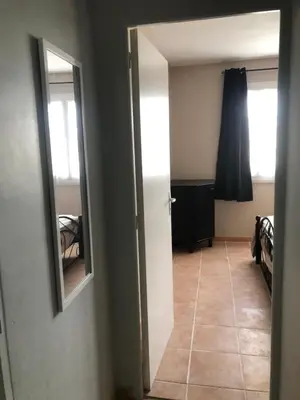 a hallway with a mirror and a room with a bed at Chez Sophie et Bernard in Saverdun