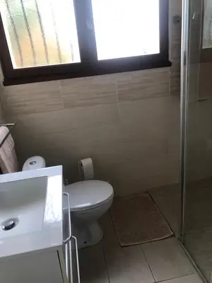 a bathroom with a toilet and a sink and a window at Chez Sophie et Bernard in Saverdun