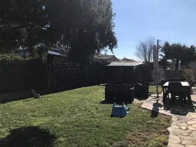 a backyard with a lawn with a table and a fence at Chez Sophie et Bernard in Saverdun