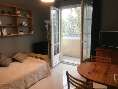a bedroom with a bed and a table and a sliding door at Chez Sophie et Bernard in Saverdun