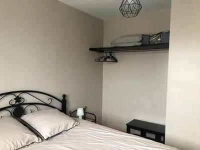 a bedroom with a bed and a shelf on the wall at Chez Sophie et Bernard in Saverdun