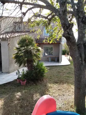 a house with a palm tree in the yard at villa au calme 6 couchages in Trèbes