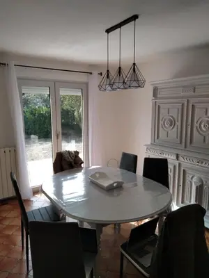 a dining room table with chairs and a laptop on it at villa au calme 6 couchages in Trèbes
