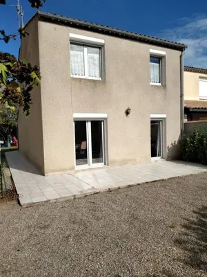 a house with two windows and a patio at villa au calme 6 couchages in Trèbes
