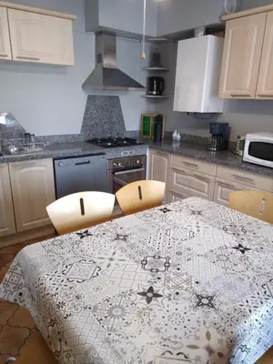 a kitchen with a table with a table cloth on it at villa au calme 6 couchages in Trèbes