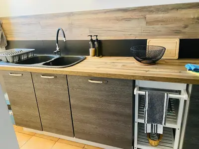 a kitchen with a sink and a wooden counter top at Maison T3 avec jardin in Narbonne