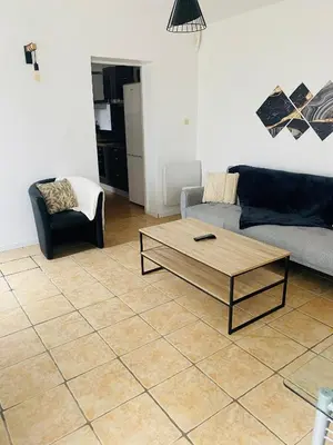a living room with a couch and a coffee table at Maison T3 avec jardin in Narbonne