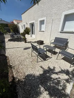 a group of benches and tables in front of a building at Maison T3 avec jardin in Narbonne