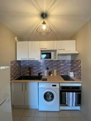 a kitchen with a washing machine and a washer at T2 Tout Confort - Parking Gratuit in Carcassonne