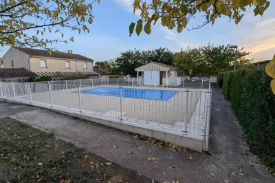 a fence around a swimming pool in a yard at T2 Tout Confort - Parking Gratuit in Carcassonne