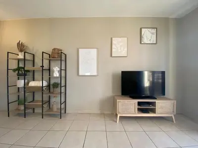 a living room with a flat screen tv and shelves at T2 Tout Confort - Parking Gratuit in Carcassonne