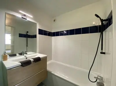 a bathroom with a tub and a sink and a shower at T2 Tout Confort - Parking Gratuit in Carcassonne