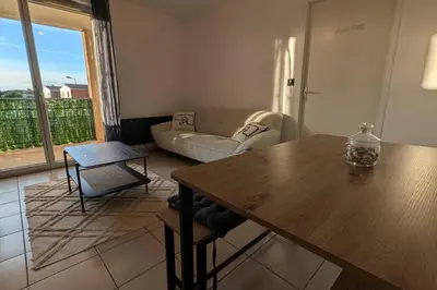 a living room with a table and a couch at T2 Tout Confort - Parking Gratuit in Carcassonne