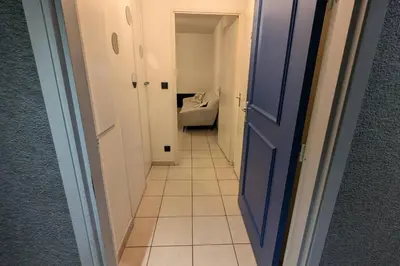 a hallway with a toilet and a blue door at T2 Tout Confort - Parking Gratuit in Carcassonne