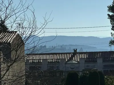a view of a building with mountains in the background at LV House & Gardens in Carcassonne