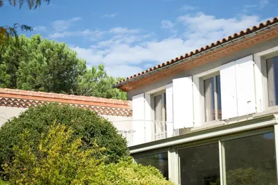 a white building with windows and trees at LV House & Gardens in Carcassonne