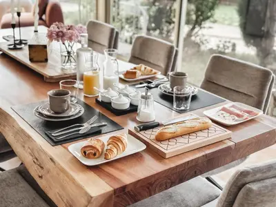 a wooden table with breakfast foods and coffee on it at LV House & Gardens in Carcassonne